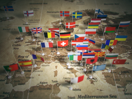 Karte Europas mit aufgesteckten Flaggen der Mitgliedstaaten der Europäischen Union, symbolisch dargestellt auf antik wirkender Landkarte.